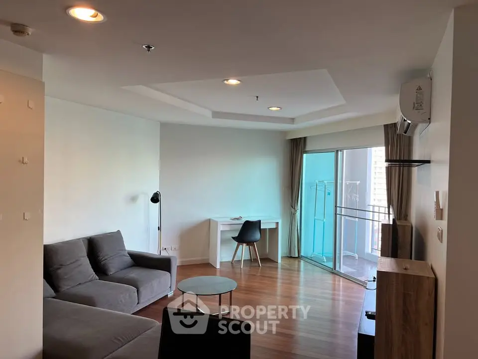 Spacious living room with modern furniture and balcony access in a stylish apartment.