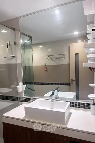Modern bathroom with sleek design, featuring a glass shower and stylish sink.