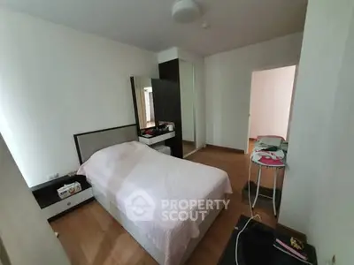 Cozy bedroom with modern furnishings and wooden flooring, perfect for a comfortable living space.