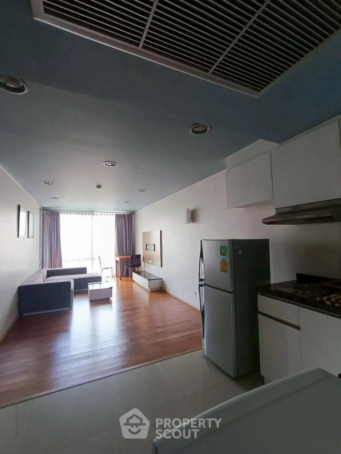 Spacious open-plan living room with modern kitchen and natural light