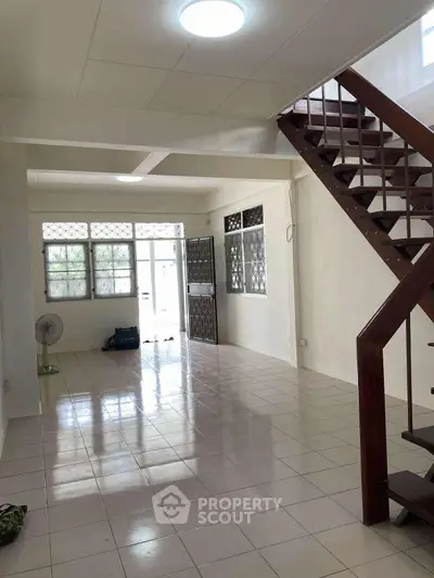 Spacious open-plan living area with staircase and natural light
