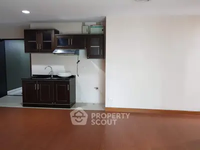 Spacious kitchen area with dark wood cabinets and sleek flooring