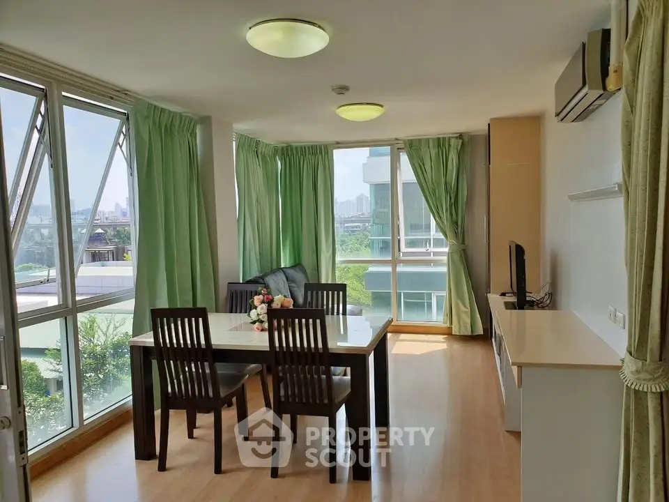 Bright and spacious living room with large windows and modern furniture in a high-rise apartment.
