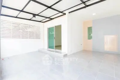 Spacious modern interior with sleek tile flooring and sliding glass doors, perfect for versatile living space.