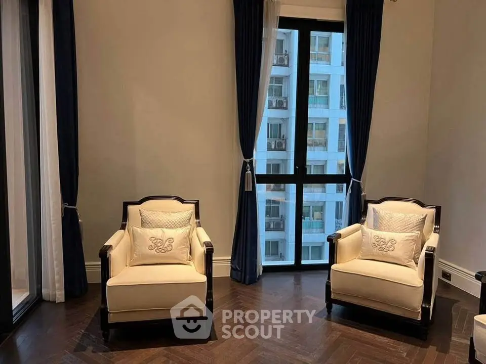 Elegant living room with two armchairs and city view through large window