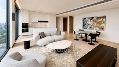 Luxurious modern living room with open kitchen and stunning city view, featuring elegant furniture and contemporary decor.