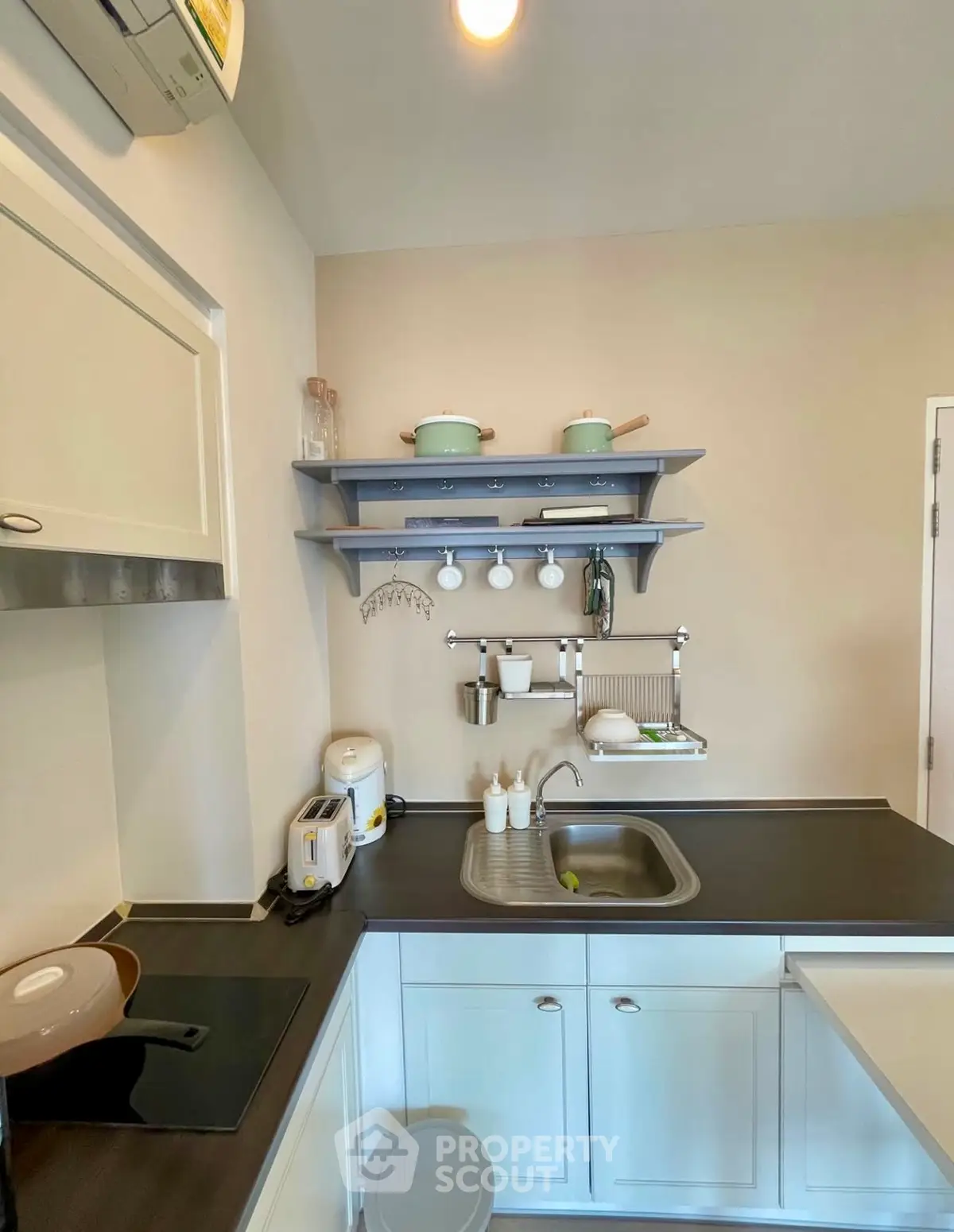 Charming kitchen with modern appliances and sleek design, featuring open shelving and efficient use of space.