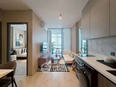 Modern open-plan living room and kitchen with stylish decor and natural light.