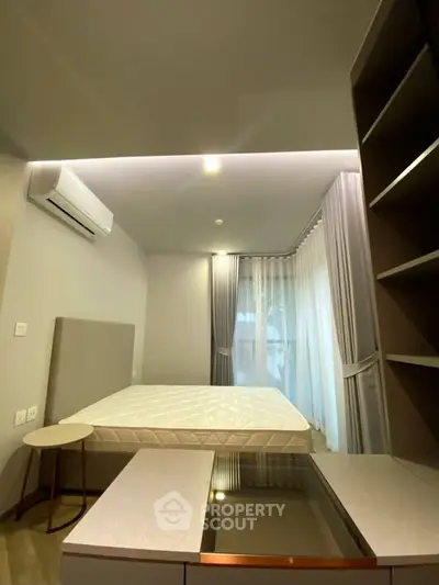 Modern bedroom with sleek design, featuring a comfortable bed and stylish furnishings.