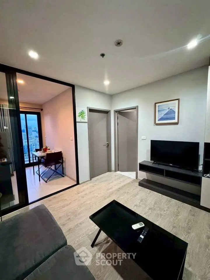 Modern living room with sleek furniture and city view from adjacent room
