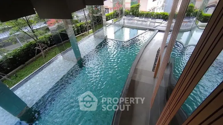 Luxurious indoor swimming pool with modern design and lush greenery view.
