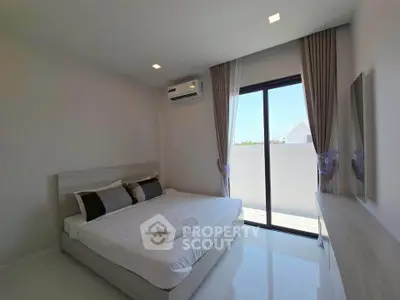 Modern bedroom with large window and minimalist decor in a bright apartment.