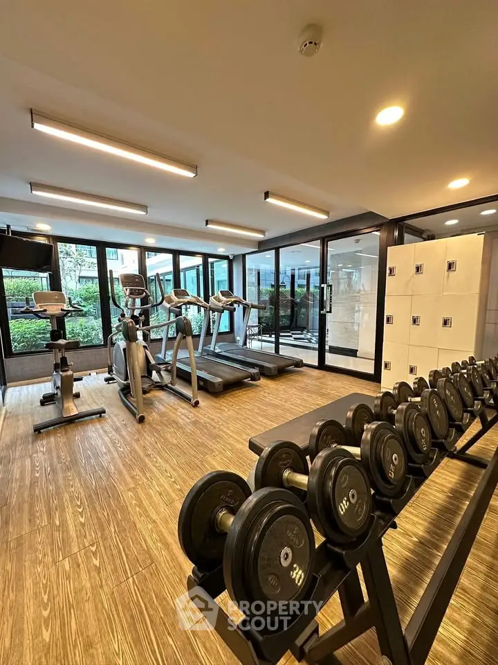 Modern gym with state-of-the-art equipment and large windows offering garden views.