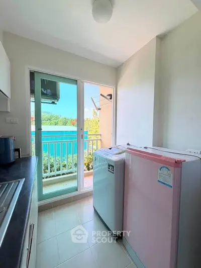 Charming kitchen with balcony view, featuring modern appliances and ample natural light.