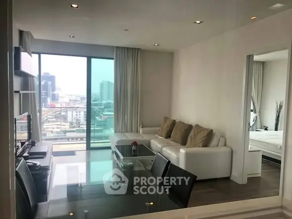 Modern living room with city view, sleek furniture, and open layout in high-rise apartment.