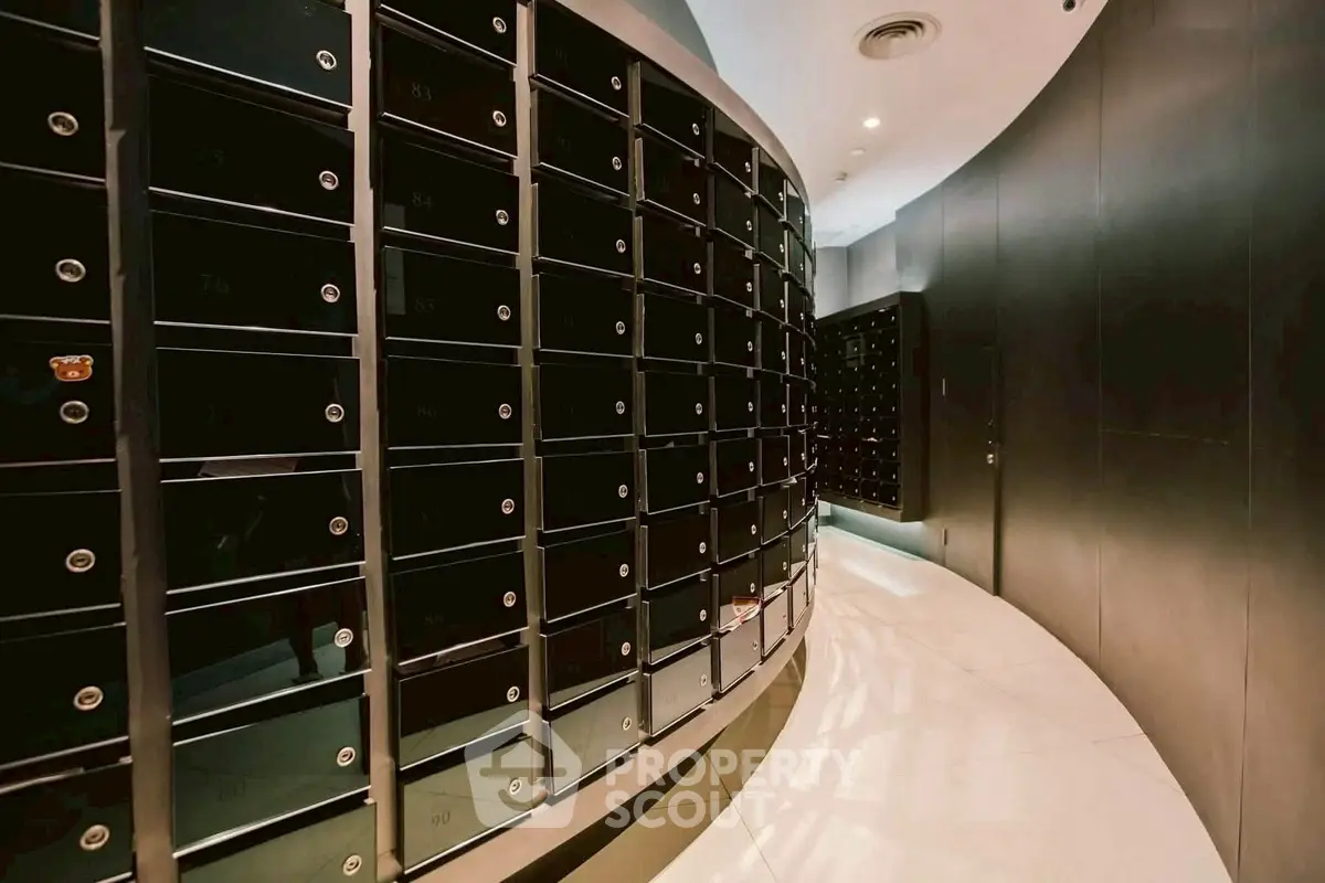 Modern apartment building mailroom with sleek black mailboxes and curved design.