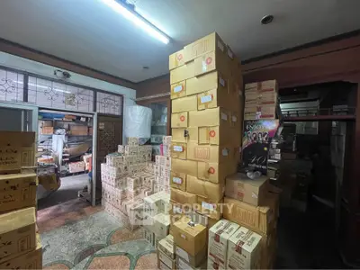 Spacious storage room filled with stacked boxes, ideal for inventory management in a commercial property.