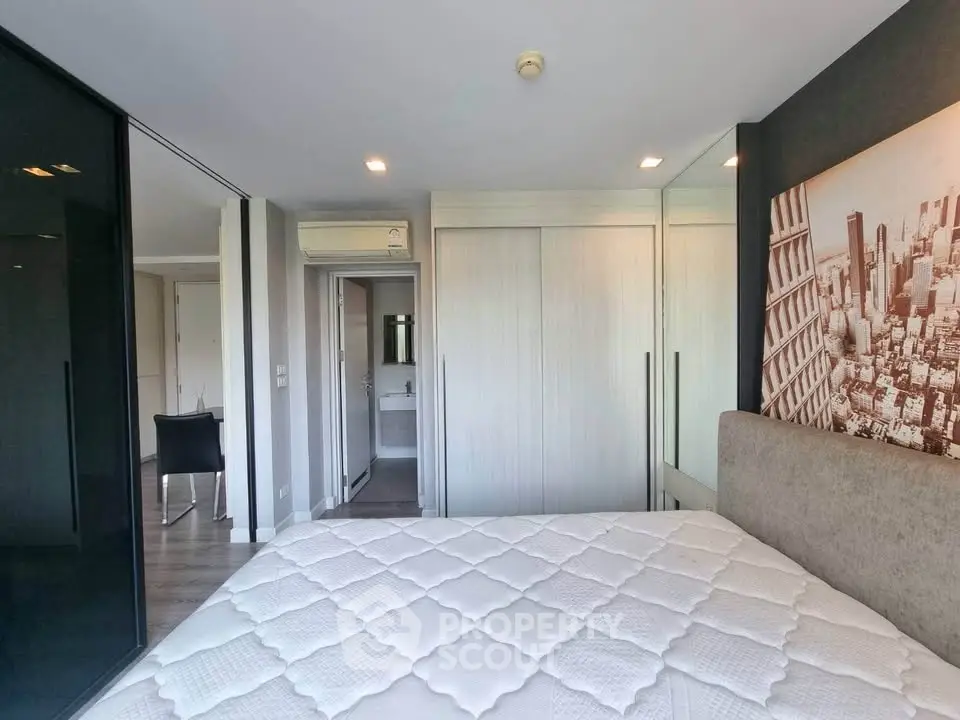 Modern bedroom with stylish decor and mirrored closet doors in a contemporary apartment.