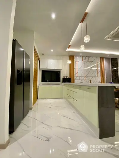 Modern kitchen with sleek design, marble flooring, and stylish lighting fixtures.