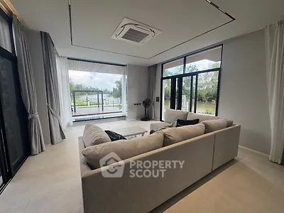 Spacious living room with large windows and scenic view, modern interior design, cozy seating area.