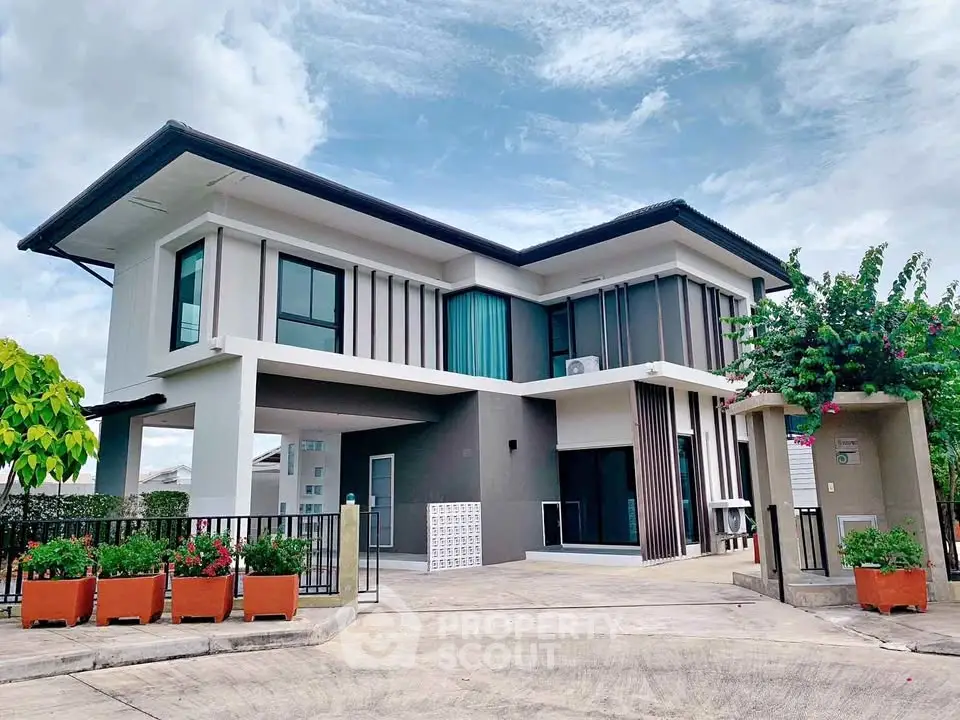 Modern two-story house with sleek design and spacious driveway in a serene neighborhood.