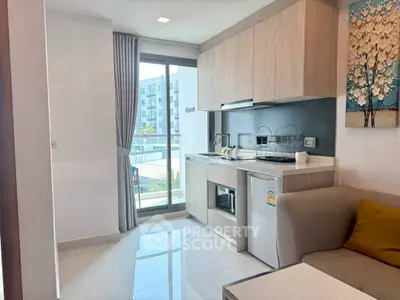 Modern compact kitchen with open layout and cozy living area in a stylish apartment.