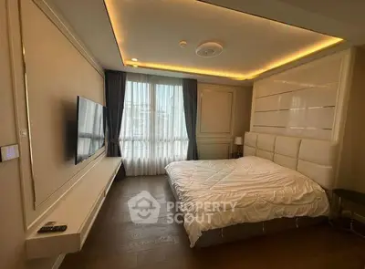 Luxurious bedroom with modern design, featuring a large bed, wall-mounted TV, and elegant lighting.