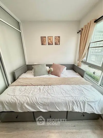 Cozy bedroom with large windows and stylish decor in modern apartment.