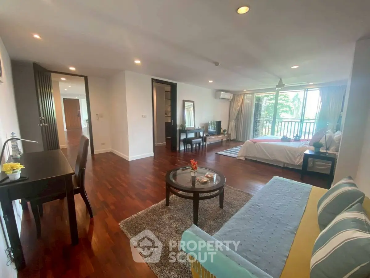 Spacious open-plan living room with elegant decor and large windows offering natural light.