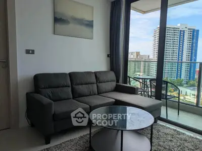 Modern living room with a stunning city view from the balcony, featuring a sleek sofa and glass coffee table.