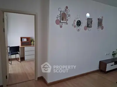 Modern living room with stylish wall decor and open view into adjacent room.