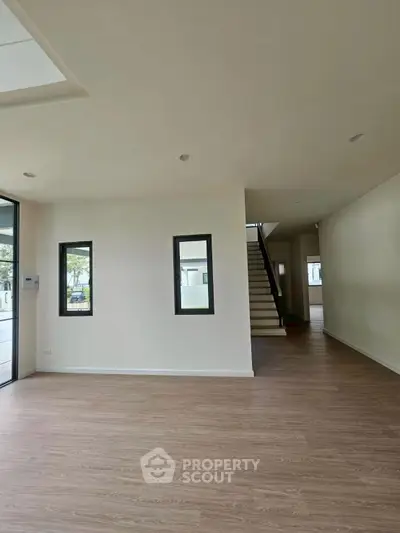 Spacious modern living room with wooden flooring and staircase