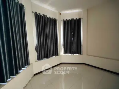 Spacious corner unit with elegant floor-to-ceiling windows and sleek tile flooring, perfect for modern living.