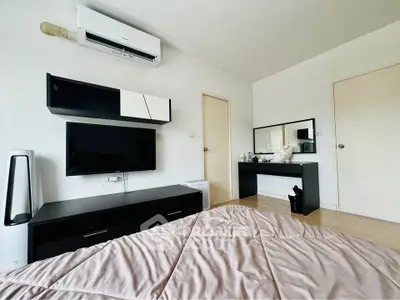 Modern bedroom with sleek black furniture and wall-mounted TV, featuring air conditioning and minimalist decor.