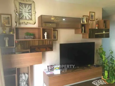 Stylish living room with modern wooden shelving and large flat-screen TV, perfect for entertainment.