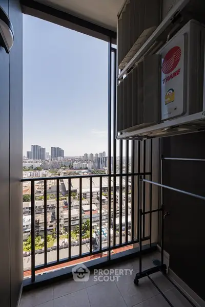 High-rise balcony with cityscape view and air conditioning unit.