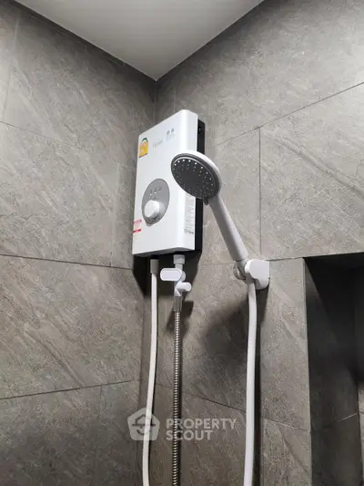 Modern bathroom with sleek showerhead and water heater on tiled wall.