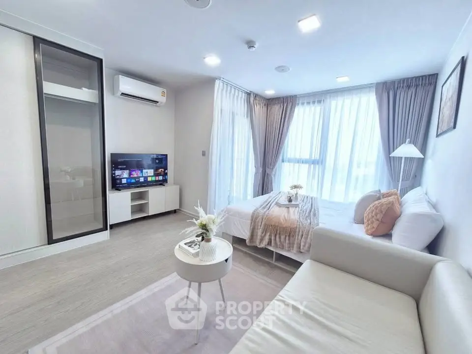 Modern studio apartment with cozy living area and large windows
