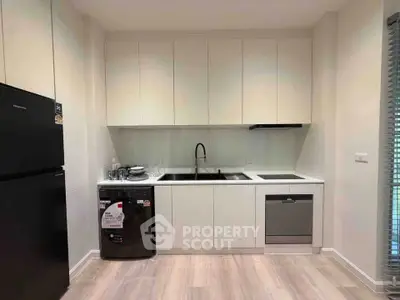 Modern kitchen with sleek cabinetry, washing machine, and dishwasher in a compact layout.