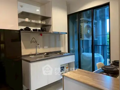 Modern kitchen with sleek cabinetry and balcony view in urban apartment
