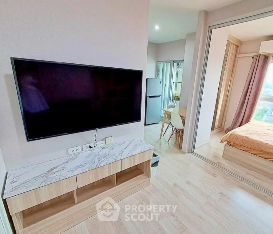 Modern apartment interior with TV, dining area, and bedroom view