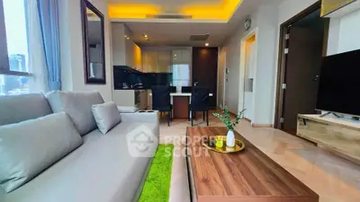 Modern living room with stylish decor and open kitchen layout in a high-rise apartment.