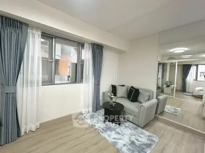 Modern living room with stylish decor and large mirror enhancing space