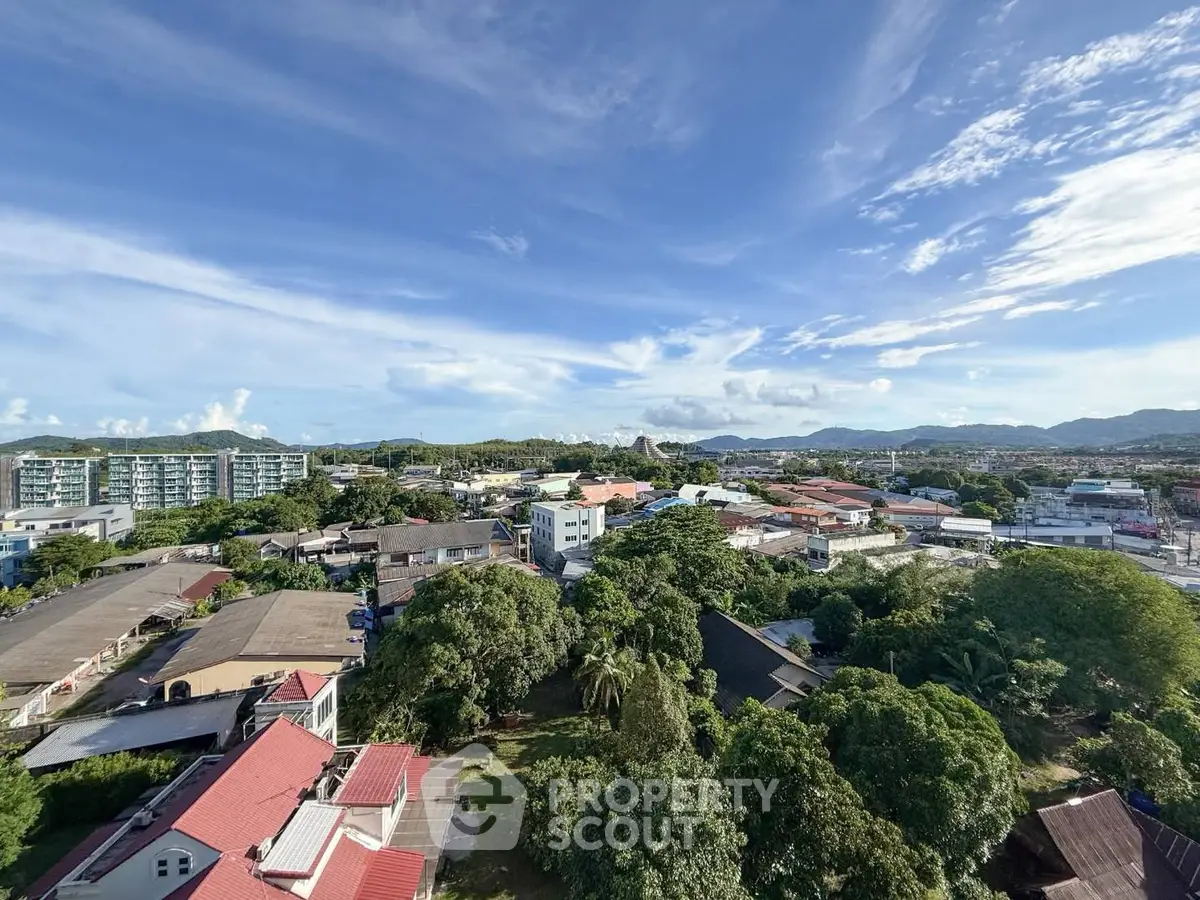 Stunning aerial view of a vibrant cityscape with lush greenery and distant mountains under a clear blue sky.