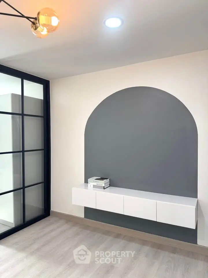 Modern minimalist interior with sleek wall-mounted cabinet and stylish lighting.