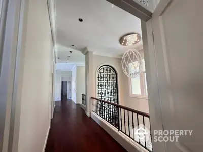 Elegant hallway with chandelier and wooden flooring in luxury home