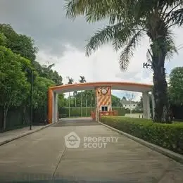 Gated entrance with lush greenery and modern design