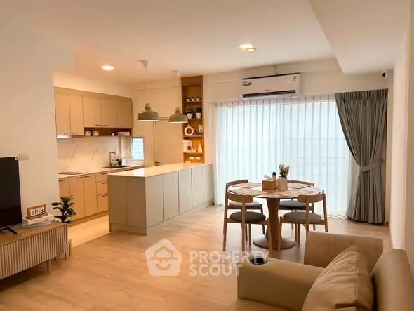 Modern open-layout kitchen and dining area with natural light and stylish decor.