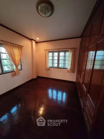 Spacious bedroom with wooden flooring and built-in wardrobe