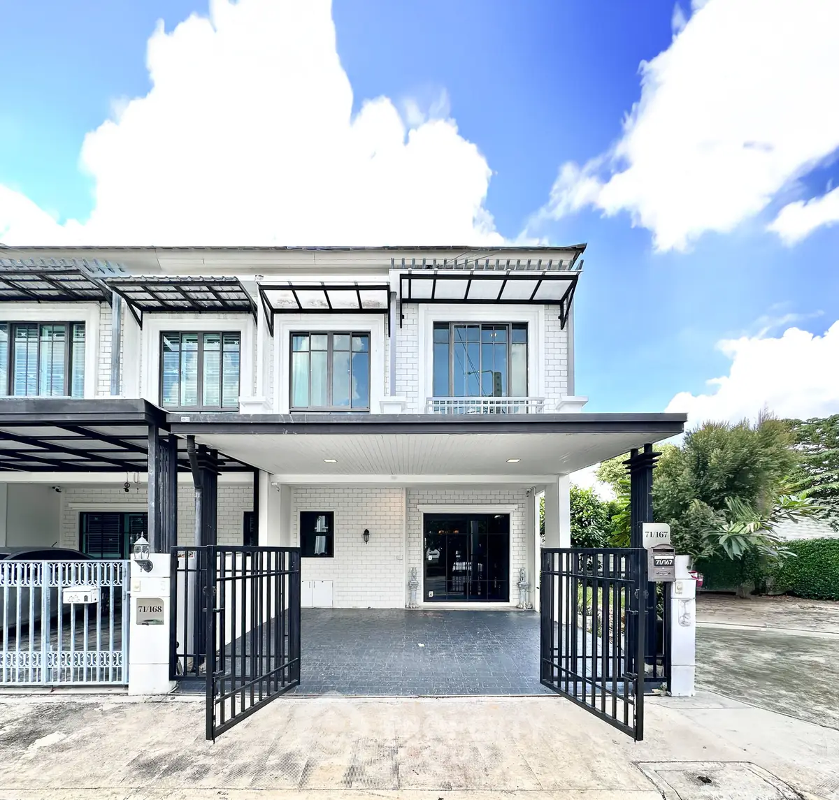 Modern two-story townhouse with gated entrance and spacious driveway